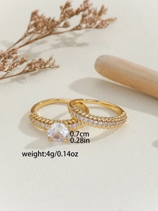 Detail view of gold grain-style rings with a 0.7cm zircon and woven texture design