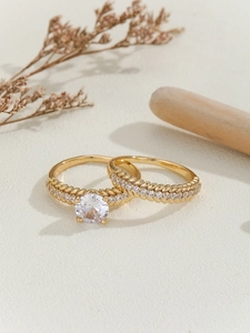 Detailed close-up of gold-plated twisted band ring set with a round zircon stone