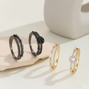 Minimalist black and gold zirconia ring set displayed on elegant stone props