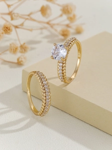 Detail of luxury gold copper ring set with zircon stones on beige decorative block