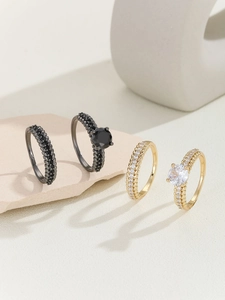 Macro shot of gold and black stacked rings set with micro-pave zircons and wheat textures