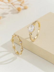Close-up of gold geometric rhumbus ring with oval zircon stone and wavy diamond band