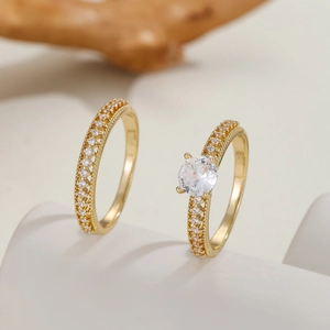 Close-up of gold-plated two-piece ring set with four-prong set solitaire and pavé band