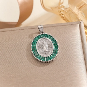 Detailansicht Maria-Anhänger mit grünen Zirkonia-Steinen auf eleganter Seiden-Schmuckbox