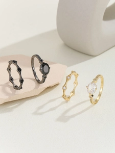 Detail of stacked vintage rings with marquise zircons and elegant engraved patterns