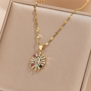 Detail of gold sunburst pendant with multicolored zircon stones on jewelry box