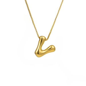 Macro detail of high-polish gold bubble letter L pendant on a fine box chain necklace