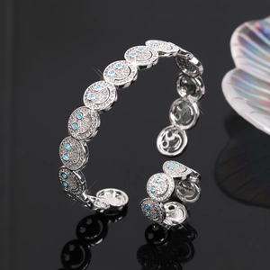 Makro-Detail des silbernen Smiley-Armreifs mit Zirkonia-Besatz und blauen Steinen