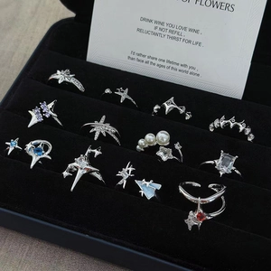 Anillos de estrella plateados ajustables con circonitas en una caja de joyería negra