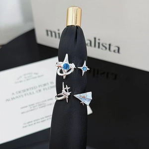 Set de anillos de plata con piedras azules y diseños de estrella, Saturno y avión
