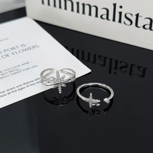 Detalle de anillos de estrella en plata con pavé de circonitas sobre espejo negro