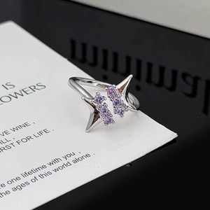 Primer plano de anillo hexagrama plateado con circonitas púrpuras en tarjeta blanca