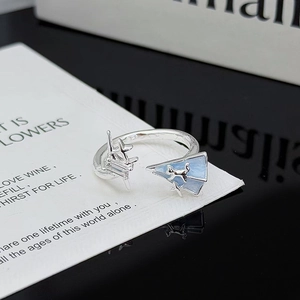 Detalle del anillo estrella de plata con avión de papel y gato de esmalte azul