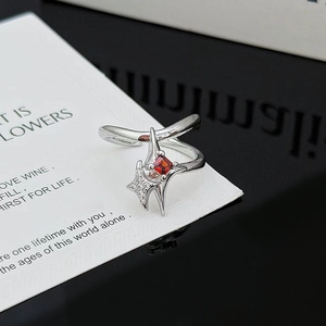 Detalle macro del anillo de estrella plateada con centro de rubí rojo y circonitas blancas