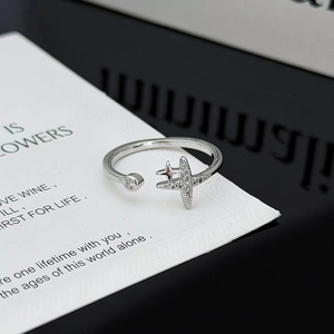 Detalle macro de anillo ajustable plateado con estrella de circón y diamantes redondos