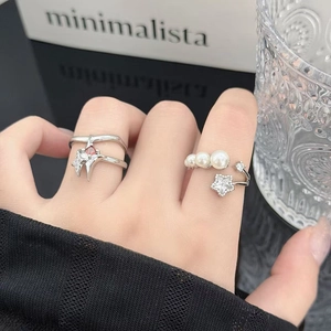 Detalle de un anillo de plata ajustable con perlas y un adorno de estrella de circonita
