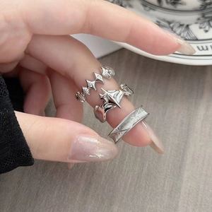 Dettaglio di un set di tre anelli gotici in argento con motivi a stella e superfici lucide