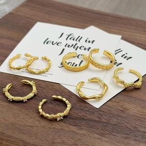 Details von sieben goldenen Vintage-Ringen mit verschiedenen Mustern auf Holztisch