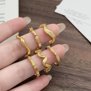 Detailansicht eines goldenen Vintage-Ring-Sets mit Wellenmustern und Zirkonia