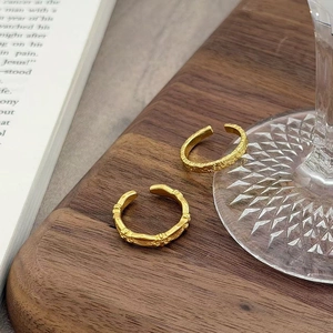 Details von goldenen Vintage-Ringen mit Textur auf einem Holztablett im Retro-Stil