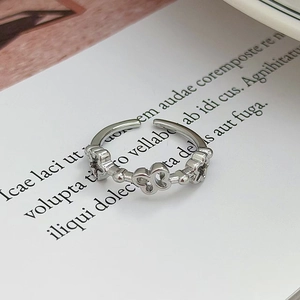 Dettaglio ravvicinato di un anello aperto in argento con farfalla e fiori traforati