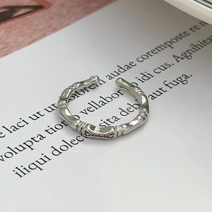 Macro di anello aperto in argento stile bambù con finitura vintage su sfondo libro