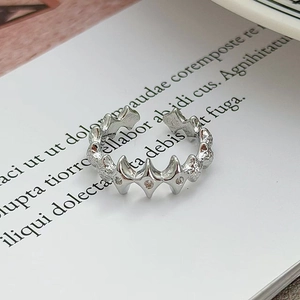 Dettaglio macro di un anello regolabile in argento con motivo a stella e zirconi