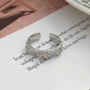Dettaglio dell'anello aperto in argento con texture verticali e rilievo a girasole
