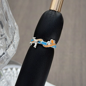 Detailaufnahme eines Flugzeug-Emaille-Rings mit blau-orangen Farben auf einem Ringständer