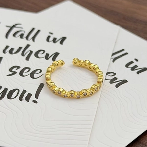 Nahaufnahme eines goldenen, verstellbaren Vintage-Rings mit weißen Zirkonia-Steinen