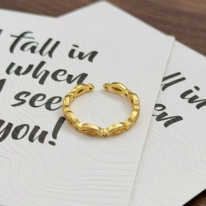 Nahaufnahme eines goldenen Vintage-Rings mit hohlen Gliedern und kleinen weißen Kristallen