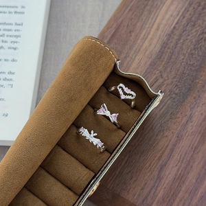Detailed macro view of heart, bow and rabbit rings with pink zircons on velvet holder