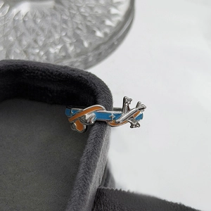 Makroaufnahme von Flugzeugring mit blauem und orangefarbenem Emaille auf Samtbox