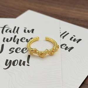 Nahaufnahme eines goldenen Kordelrings im Vintage-Stil mit gewebter Textur auf Karte