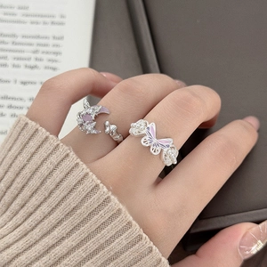 Close-up of butterfly and moon open rings set with purple enamel and small pearls