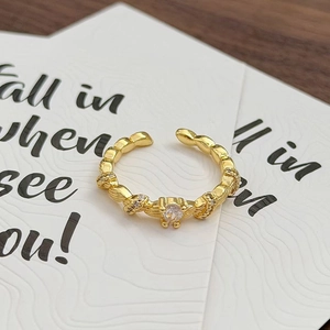 Detailansicht eines vintage gedrehten Goldrings mit Zirkonia auf einer eleganten Karte