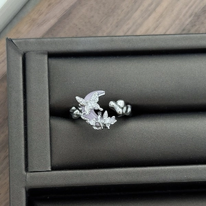 Close-up of silver ring with purple moon stone and diamond butterfly details