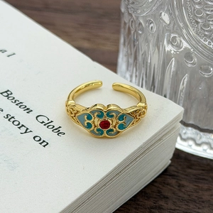 Dettaglio dell'anello smaltato retrò con pietra rossa e motivi tradizionali di nuvole