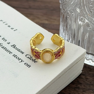Dettaglio macro di anello vintage smaltato con opale bianco e artigianato floreale