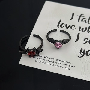 Close-up of gothic black wings ring with vibrant heart-shaped gemstones and crystal accents