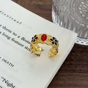 Dettaglio ravvicinato dell'anello smaltato retrò con gemma rossa e motivi floreali