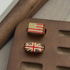Detailopname van vintage vlagringen met emaille en zirkoon op een donkere houten display