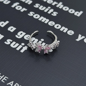 Dettaglio anello fiocco argento con zirconi rosa e bianchi in un design aperto regolabile