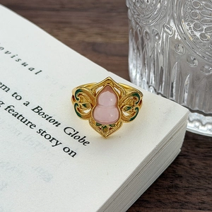 Dettaglio dell'anello a zucca rosa con nuvole in smalto verde su carta vintage