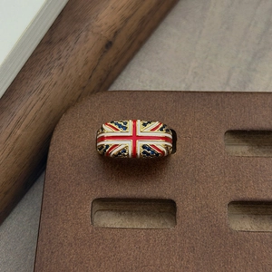 Macro-detail van de Union Jack-ring met blauwe zirkoon en vintage goudlaag