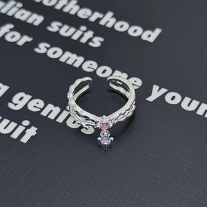 Dettaglio dell'anello ondulato argento con ciondoli in zircone rosa e viola, aperto