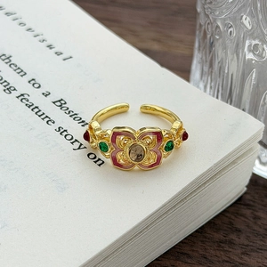 Dettaglio di anello vintage in smalto con gemma e filigrana su libro antico