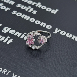 Dettaglio macro dell'anello d'argento con gemma a stella rosa e accenti di perle