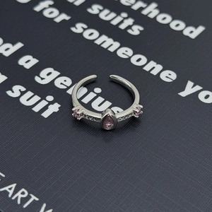 Dettaglio anello regolabile in argento con zircone rosa a goccia e pietre d'accento