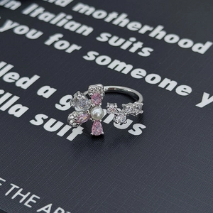 Dettaglio anello floreale argento con pietre rosa, perla e zirconi su carta nera